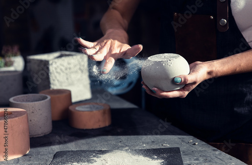 Close up of craftswoman hands making decorative concrete vase in her workshop. photo