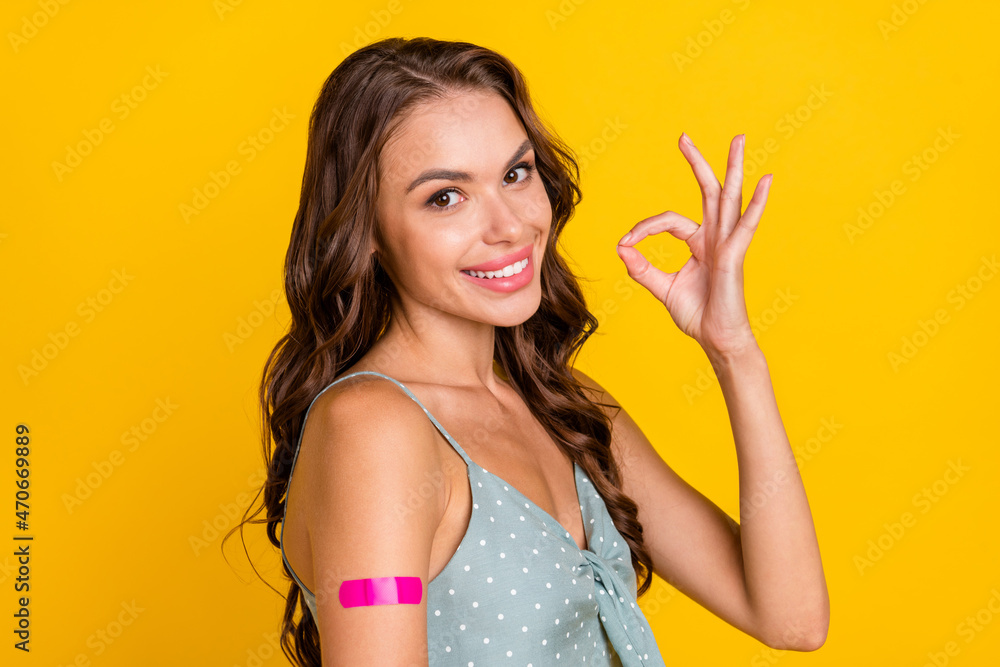 Photo of young brunette woman show okay sign wear dotted singlet vaccine isolated on yellow color background Photo of young brunette woman show okay sign wear dotted singlet vaccine isolated on yellow color background