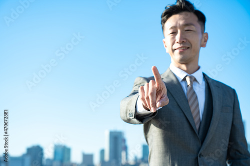 人差し指を立てるポーズをするビジネスマン
