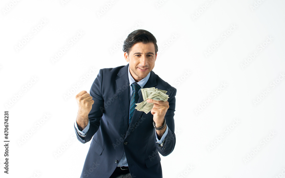 Handsome smart Caucasian businessman wearing formal suit, necktie, smiling with happiness, success, raising hand, doing gesture yes, win, holding dollar banknotes on isolated white background cutout. Handsome smart Caucasian businessman wearing formal suit, necktie, smiling with happiness, success, raising hand, doing gesture yes, win, holding dollar banknotes on isolated white background cutout.