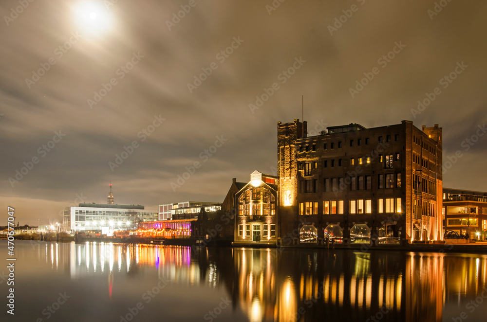 Haarlem, The Netherlands, November 19, 2021: night view with light of the Moon of the Spaarne river with the old Droste factory and other industrial heritage