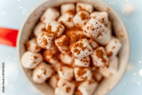 A mug of cocoa with marshmallows and a Christmas garland. A festive concept. Close up, top view