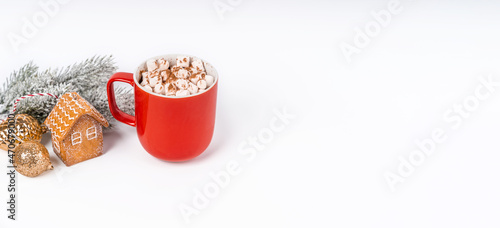 Red Christmas cocoa mug with marshmallow on a white background with gingerbread. Copy space banner