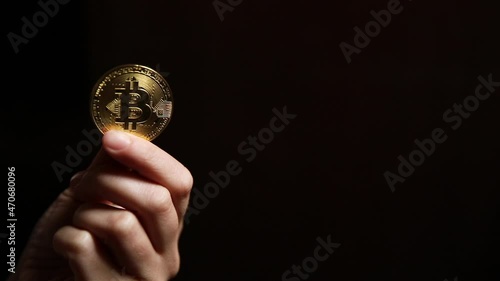 Woman hand holding cryptocurrency golden bitcoin coin ondark background. Electronic virtual money for web banking and international network payment. Symbol of crypto virtual currency. Mining concept photo