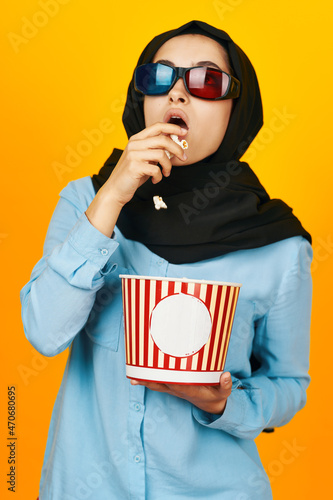 arab woman 3D glasses watching movies in the cinema yellow background © VICHIZH