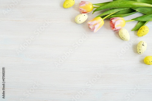 Easter background with space for text or product  pink  yellow tulips and decorative eggs.