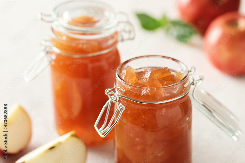 Apple jam in a glass jar. Apple jam on a light background. Delicious natural marmalade. Apple jam in a glass jar. Apple jam on a light background. Delicious natural marmalade.