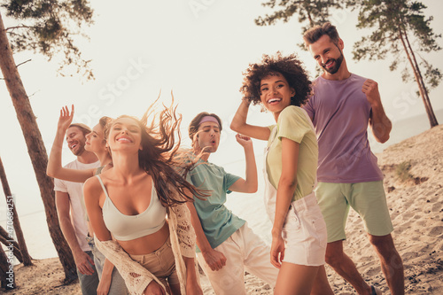 Portrait of attractive cheerful people group spending day dancing chill out having fun at beach outdoors