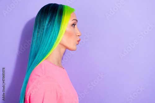 Profile side photo of carefree lady with yellow blue haircut send air kiss empty space isolated over purple color background