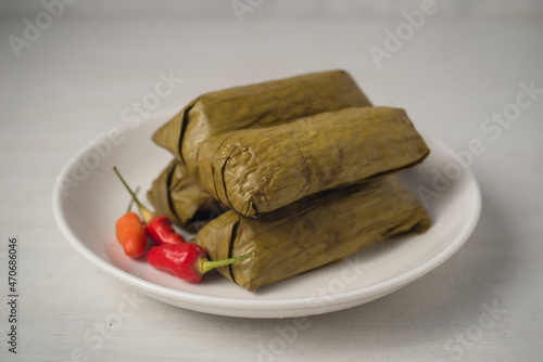 Red rice lontong or rice cake with spicy beef floss filling. Lontong or Rice cake is Indonesian dish made of compressed rice cake in the form of a cylinder wrapped inside a banana leaf then steam it. photo