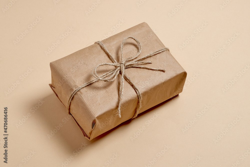 eco gift box with twine bow. ready-made wrapped kraft paper gift on beige background eco gift box with twine bow. ready-made wrapped kraft paper gift on beige background