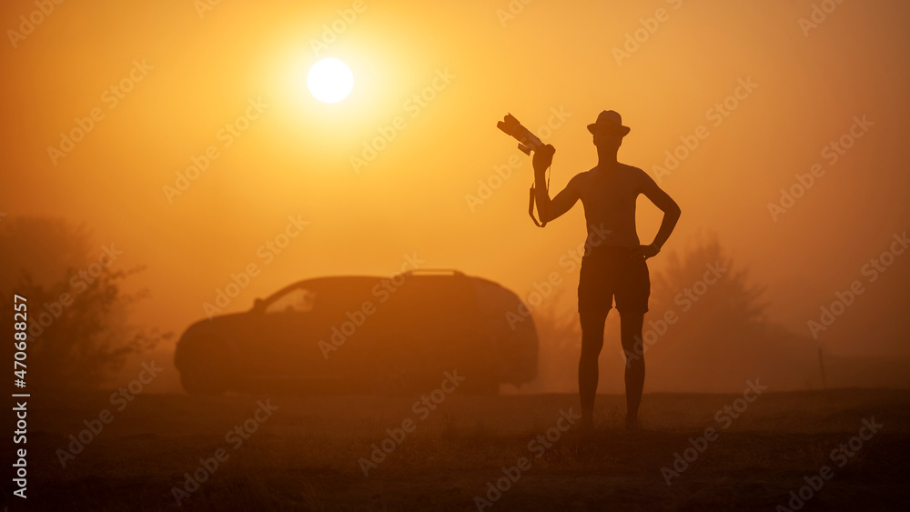 Man with a camera at sunset in a sandstorm