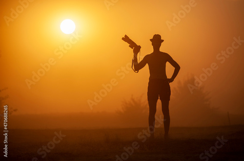 Man with a camera at sunset in a sandstorm