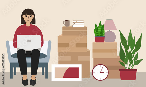 A woman at home with a laptop sits in a chair. The concept of online registration of delivery of boxes, goods and assistance in moving.