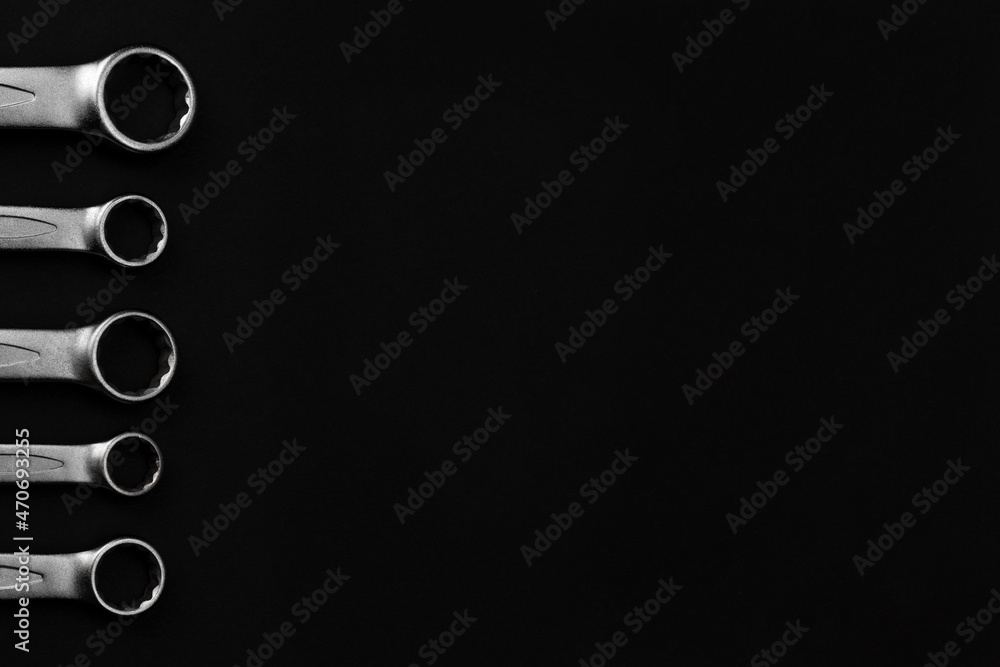 Steel closed end ring wrenches on black background with copy space