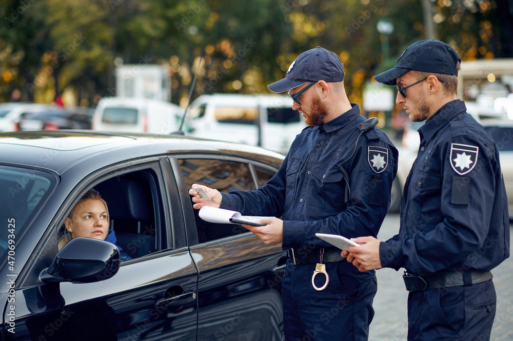 Fototapeta premium Male police officers checking the driving license