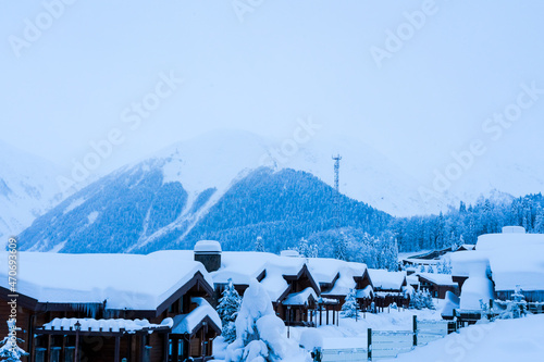 Village in the snow in the Caucasus mountains in an early foggy morning