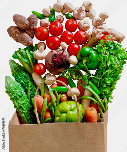 Fresh fruits and vegetables in a paper bag on white, copy space, banner. Shopping food supermarket and clean vegan eating concept. Top view.