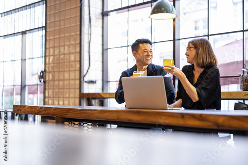 Bild auf Leinwand Multiracial friends or business partners talking and drinking beer in modern pub