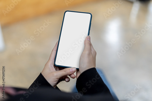 Smartphone blank screen, person holding smartphone and looking at blank screen, mockup screen for further editing can be used in a variety of tasks. copy space. © kamiphotos