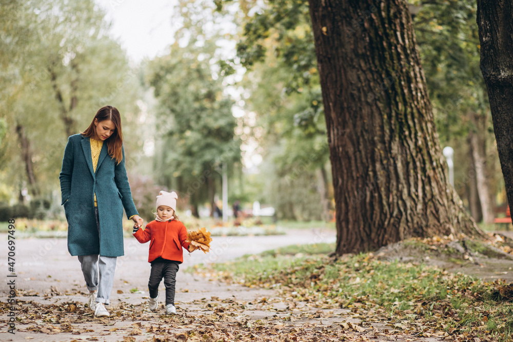 Fototapeta premium Young mother with her little daughter in an autumn park