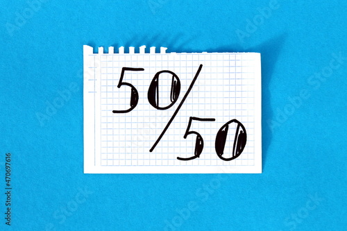  It says 50-50 on white squared notebook paper.