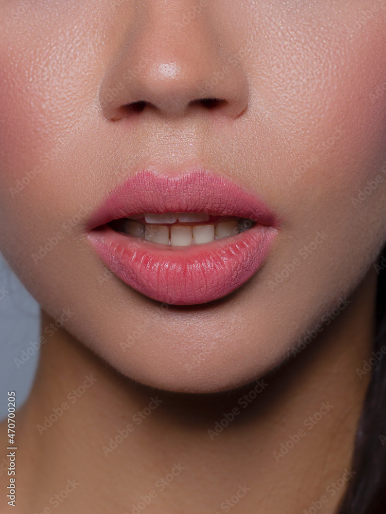 Cosmetics, makeup and trends. Bright lip gloss and lipstick on lips. Closeup of beautiful female mouth with natural lip makeup. Beautiful part of female face. Perfect clean skin in natural light