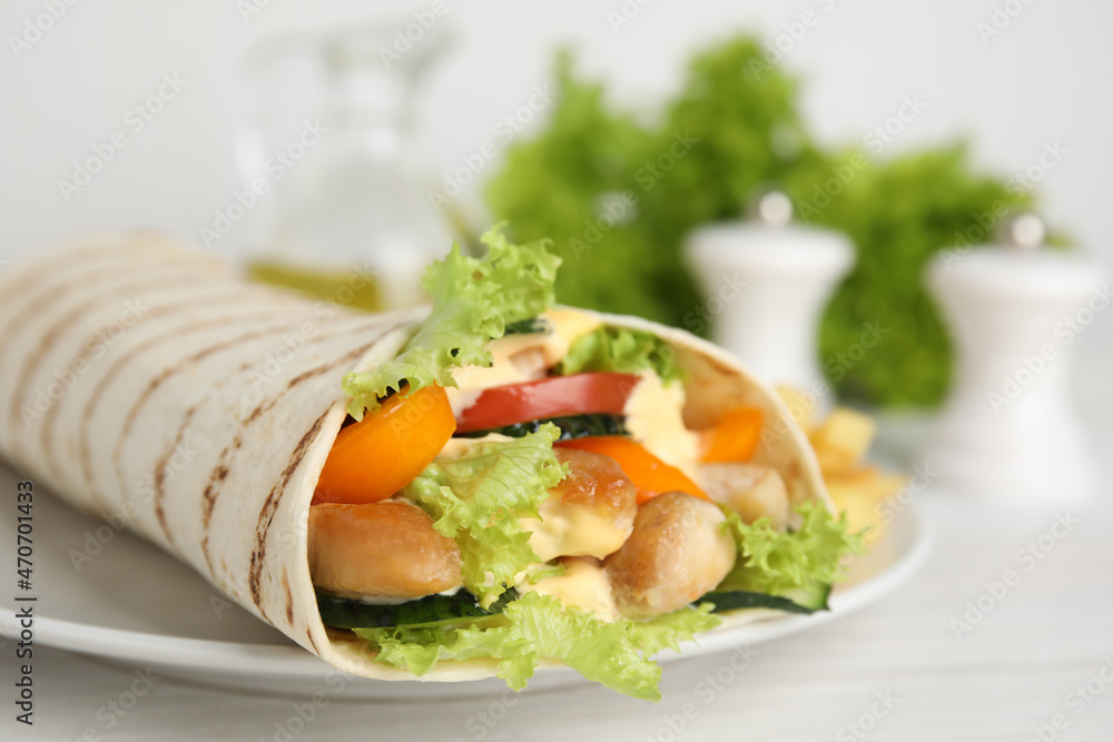 Delicious shawarma with chicken meat and fresh vegetables served on white wooden table, closeup