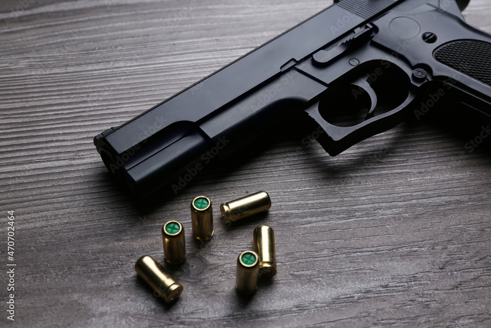 Pistol and bullets on wooden table. Professional gun Pistol and bullets on wooden table. Professional gun