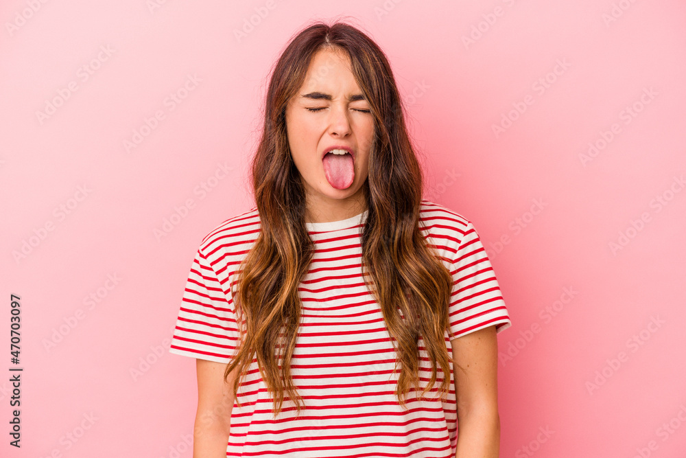 Young caucasian woman isolated on pink background funny and friendly sticking out tongue. Young caucasian woman isolated on pink background funny and friendly sticking out tongue.