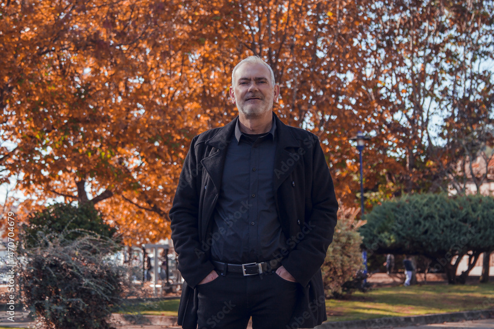 man in coat posing in autumn background man in coat posing in autumn background