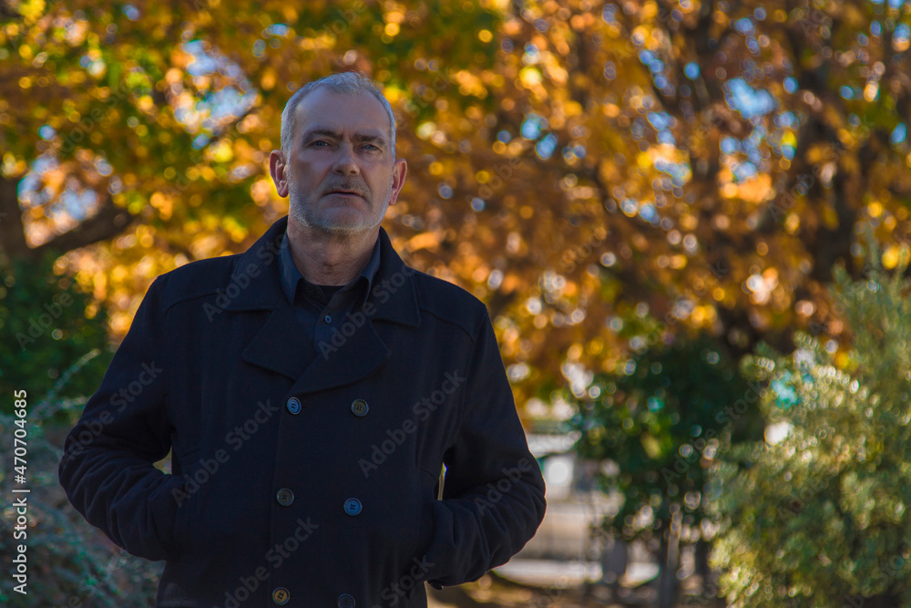 man in coat posing in autumn background man in coat posing in autumn background