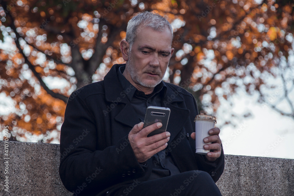 relaxed man using mobile phone while having coffee relaxed man using mobile phone while having coffee