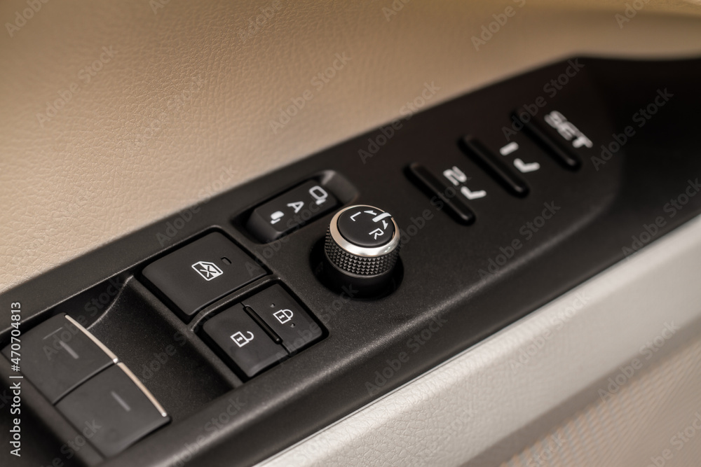 Side mirrors control panel on side door. Car driver adjust side mirror controller. Side mirror control button for adjusting the side mirrors. Side mirrors control panel on side door. Car driver adjust side mirror controller. Side mirror control button for adjusting the side mirrors.