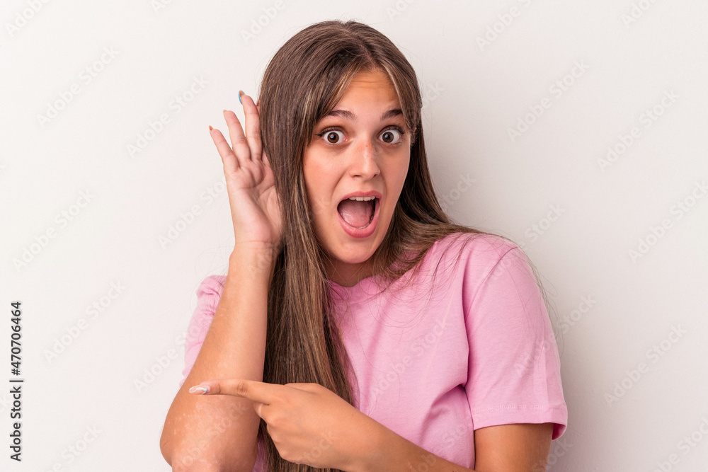 Young caucasian woman isolated on white background trying to listening a gossip. Young caucasian woman isolated on white background trying to listening a gossip.