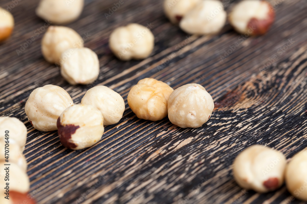 peeled and roasted hazelnuts on a wooden table peeled and roasted hazelnuts on a wooden table