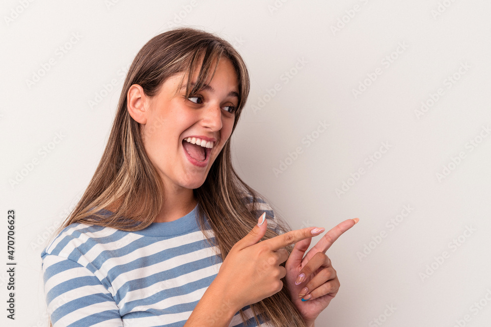 Young caucasian woman isolated on white background points with thumb finger away, laughing and carefree. Young caucasian woman isolated on white background points with thumb finger away, laughing and carefree.