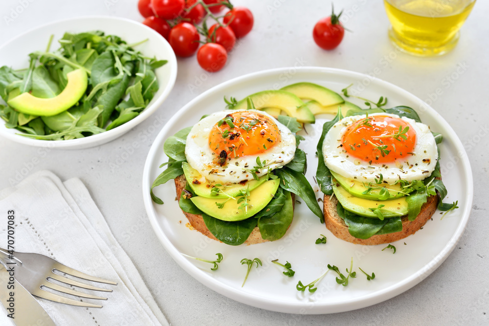 Bread with fried eggs, avocado and greens Bread with fried eggs, avocado and greens