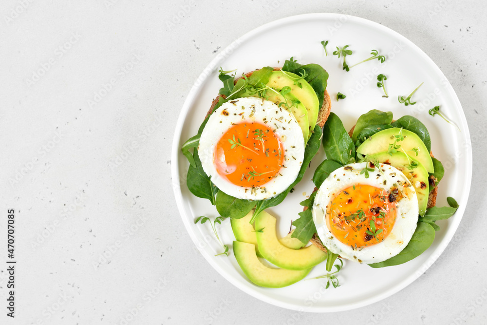 Bread with fried eggs, avocado and greens Bread with fried eggs, avocado and greens