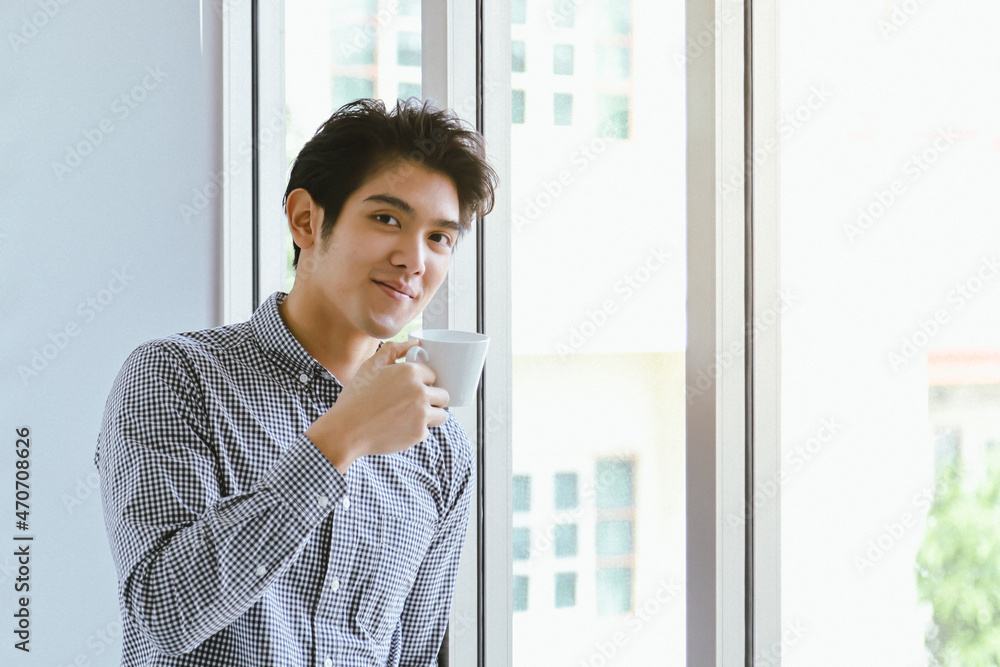 Portrait of smart young asian businessman smiling looking to camera and holding white cup of hot coffee. Portrait of smart young asian businessman smiling looking to camera and holding white cup of hot coffee.