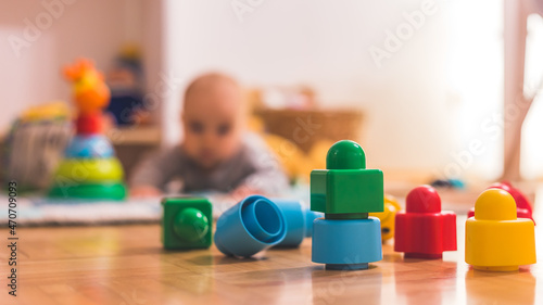 Canvastavla Baby toddler playing concept: Colorful toy blocks in the foreground, playing bab