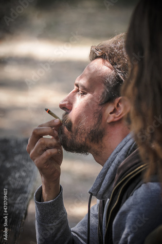 Closeup detail view of man smoke marijuana ganja joint cigarette