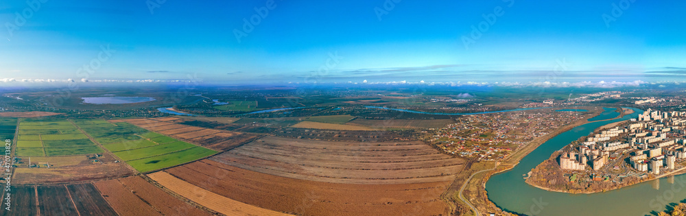 the Yubileiny microdistrict of the city of Krasnodar on the bend of the Kuban River and the rice fields of the Adyghe coast - a large aerial panorama on a sunny day in late autumn
