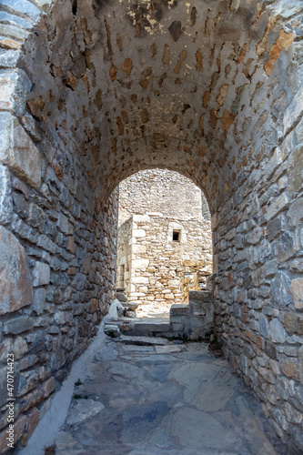 Empty path covered with arch stonewall shelter at Vathia Mani Laconia Peloponnese Greece. Vertical