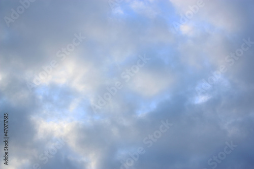 Blurred sky background with the sunlight and soft clouds. Autumn.