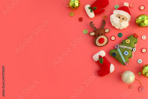 Christmas composition with copy space on red background of handmade felt toys flat lay. Red toy car, felt santa, deer, christmas tree, mittens on red background. Concept of Christmas new year.  photo