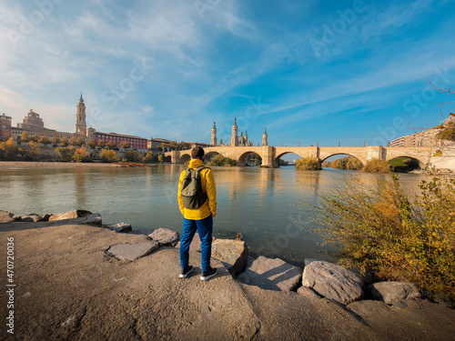 Boy looking at the river Ebro under the Puente de Piedra and in front of the Basilica del Pilar in Zaragoza, Aragon. Spain. photo