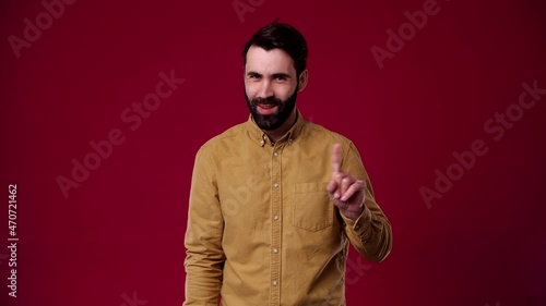 I'm not going anywhere, this is all nonsense, look for someone else, the guy shows that he doesn't want to go anywhere, he is bearded, dark-haired, dressed in a brown shirt, the background is red