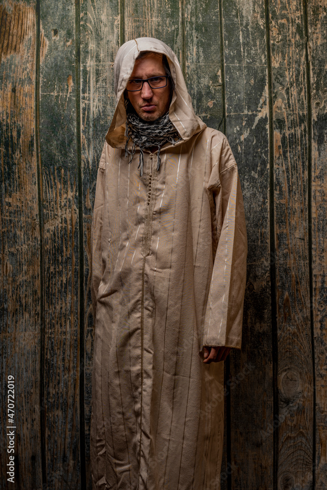 Man with long priest dress with wooden old wall Man with long priest dress with wooden old wall