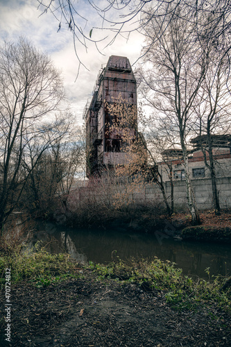 a rusty metal structure stands across the river